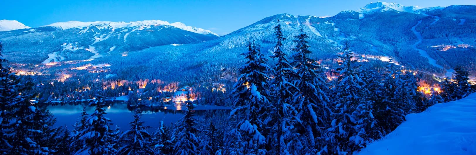 Whistler Blackcomb ski resort panoramic view showing dual mountain peaks, PEAK 2 PEAK gondola connecting Whistler and Blackcomb mountains, Olympic downhill slopes with fresh powder snow, village base area with skiers, and Coast Mountains British Columbia backdrop - Canada's largest ski resort 8,171 acres 2025