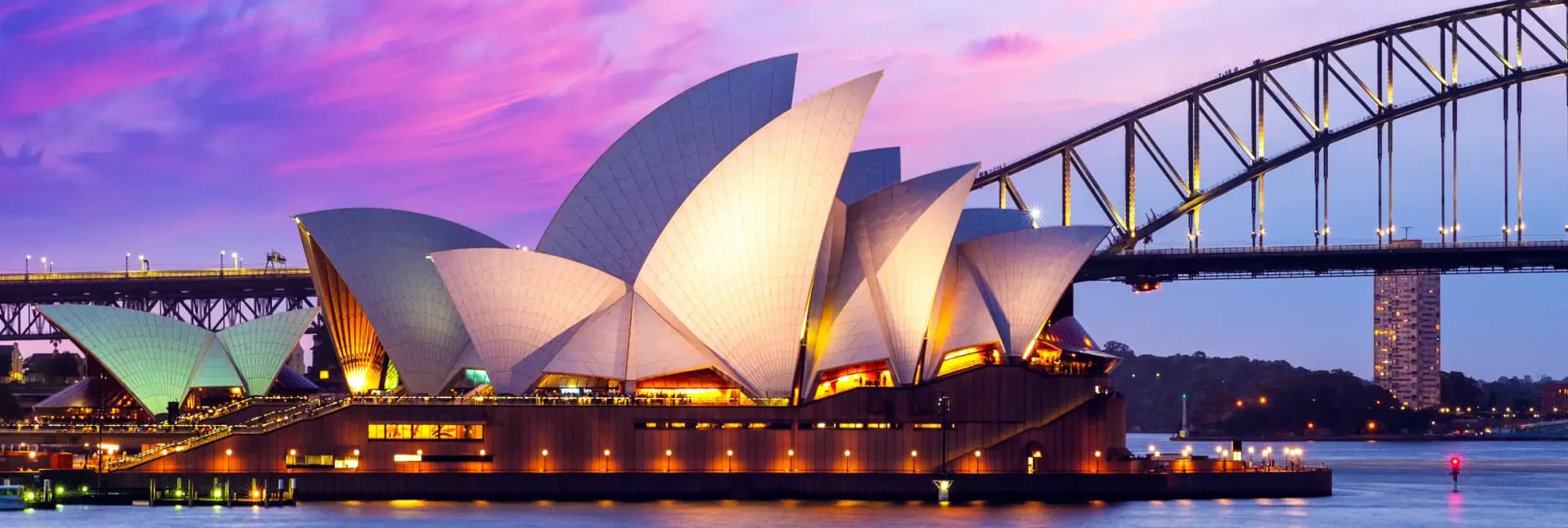 Sydney Australia in December 2025 featuring iconic Opera House with white sail-shaped roof and Sydney Harbour Bridge spanning the harbor, blue skies over sparkling water with sailboats, showcasing perfect summer weather for New Year's Eve celebrations and beach activities in Sydney's harbor cityscape