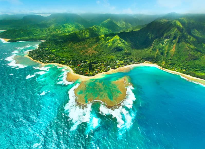 Hawaii in November 2025 - dramatic Na Pali Coast emerald cliffs and turquoise lagoons on Kauai, lush tropical rainforest valleys, perfect beach weather before humpback whale season begins, Road to Hana waterfalls and volcanic landscapes during shoulder season paradise