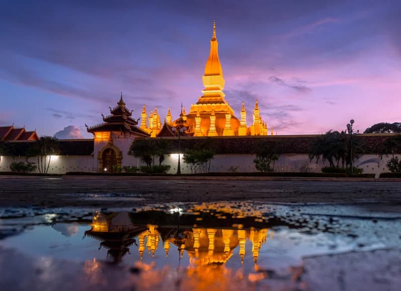 Laos in November 2025 - ancient Buddhist temples and saffron-robed monks at sunrise in Luang Prabang, Mekong River cruise boats, turquoise Kuang Si waterfall pools, and Vang Vieng limestone karst mountains during post-monsoon season best time to visit Southeast Asia
