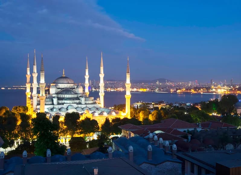 Turkey in November 2025 - colorful hot air balloons floating over Cappadocia fairy chimney rock formations at sunrise, Blue Mosque illuminated at dusk in Istanbul, ancient Ephesus Roman ruins, and Pamukkale white travertine terraces during perfect autumn weather