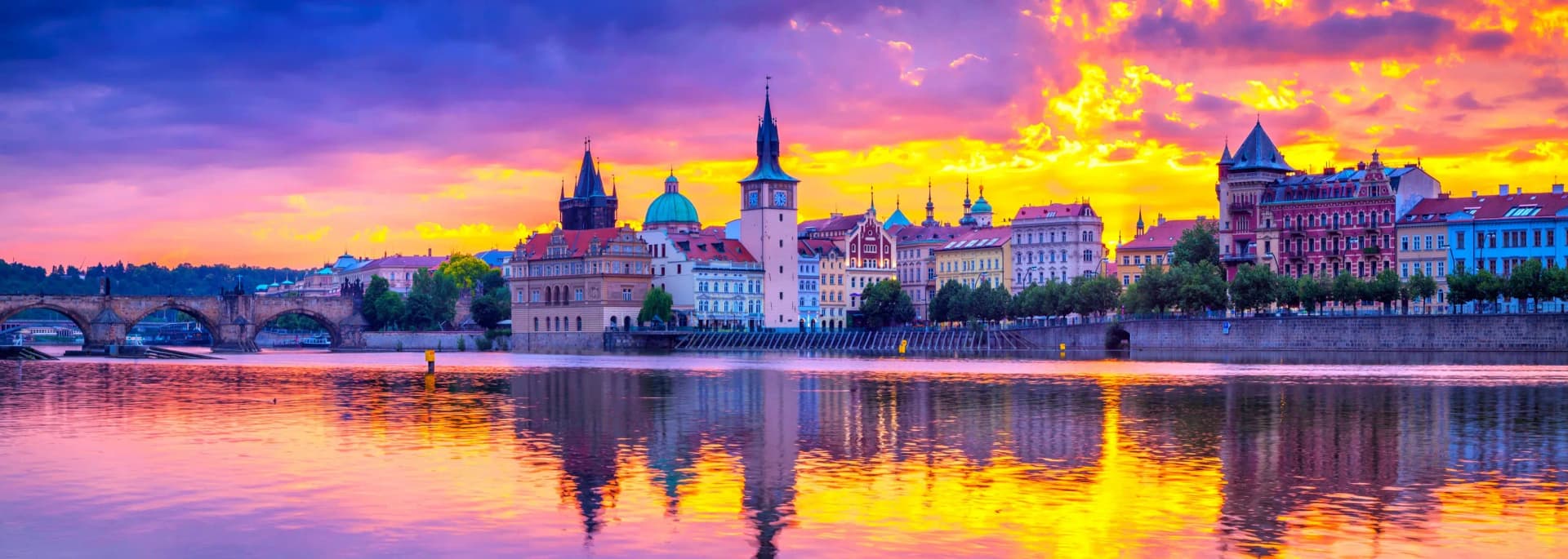 Prague Czech Republic 2026 travel guide - breathtaking aerial golden hour view of Old Town Square featuring the iconic Astronomical Clock tower, Gothic Týn Church twin spires, historic Charles Bridge spanning the Vltava River, majestic Prague Castle on Hradčany hill, terracotta red tile rooftops, Baroque and Renaissance architecture, UNESCO World Heritage cityscape perfect for budget travelers seeking European history and culture