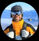 Jake Morrison - Colorado ski expert and winter sports journalist specializing in Rocky Mountain ski resorts, photographed outdoors wearing adventure gear with mountain scenery in background