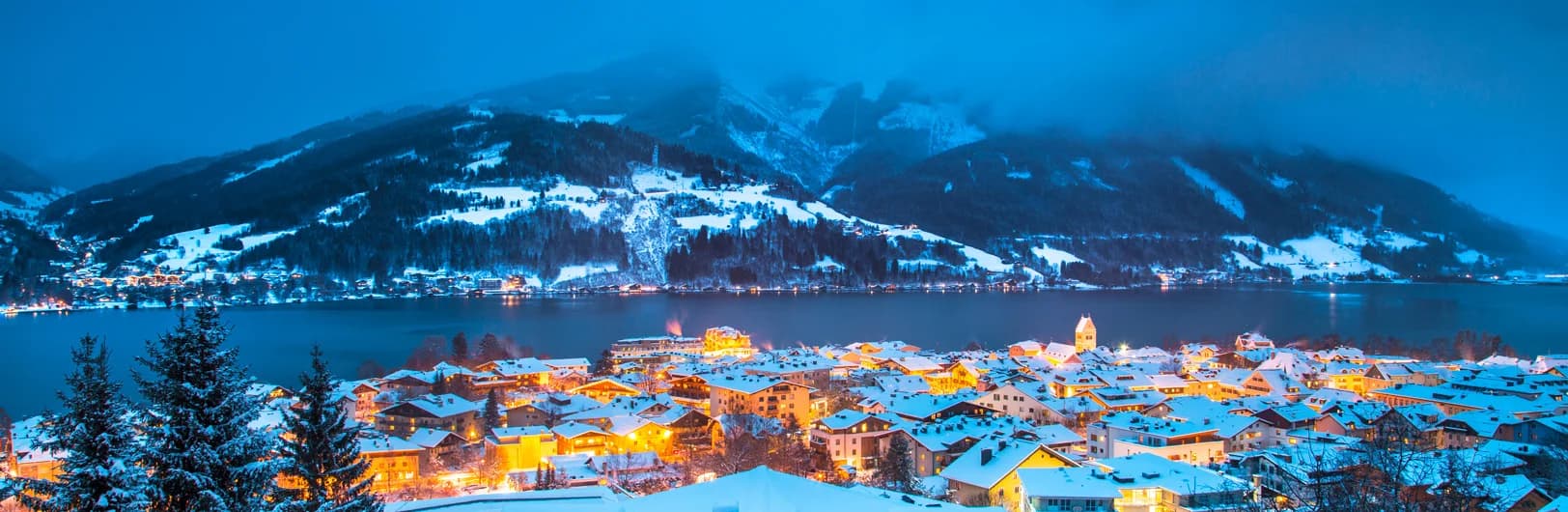 Zell am See-Kaprun Austria family ski resort 2026 - crystal blue Lake Zell with snow-covered Schmittenhöhe mountain, Kitzsteinhorn glacier, medieval lakeside town and family-friendly ski slopes