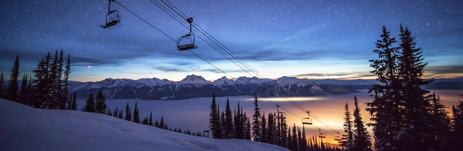 Revelstoke Mountain Resort impressive vertical terrain showcasing North America's greatest 5,620 feet continuous vertical drop, steep alpine bowls filled with legendary Interior powder snow, cat-skiing operations accessing backcountry terrain, Selkirk Mountains towering peaks, historic downtown Revelstoke mountain village, and expert skiers descending challenging chutes - British Columbia's premier powder destination 2026