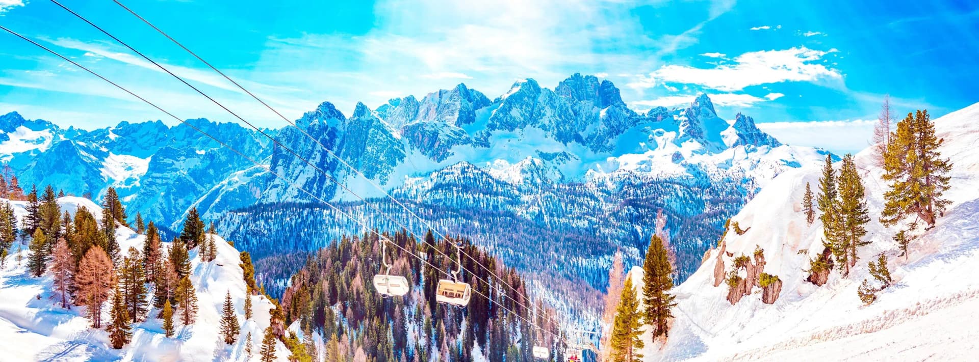 Cortina d'Ampezzo ski resort in the Italian Dolomites, snow-covered Tofane and Cristallo peaks above the town, Faloria cable car and Corso Italia pedestrian centre in winter