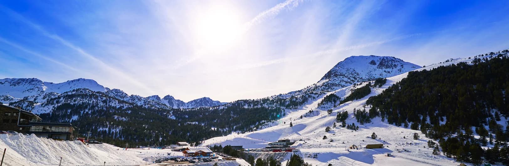 Grandvalira Andorra ski resort 2025/26 season - sunny Pyrenees mountain panorama with 210km of groomed blue and red slopes, families skiing on wide beginner-friendly pistes, modern ski lifts across Soldeu and Grau Roig sectors, snow-capped peaks under clear blue skies in tax-free Andorra