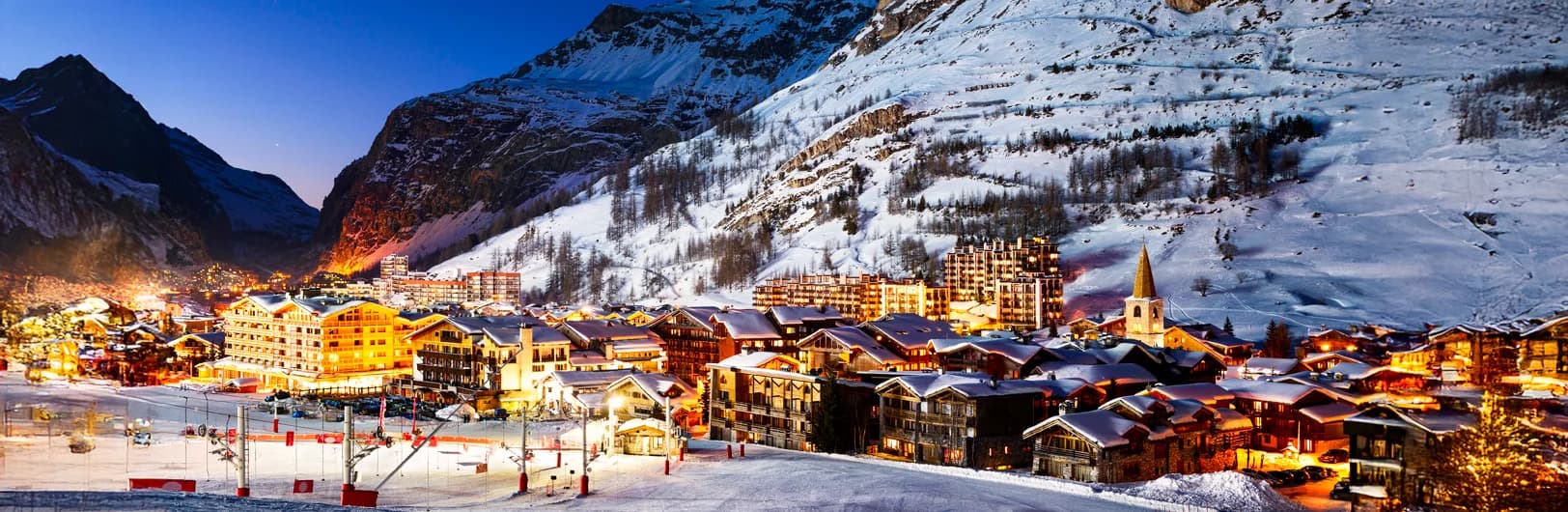 Val d'Isère ski resort France - panoramic view of world-class Espace Killy ski domain with 300km slopes, traditional Savoyard village architecture, Olympic downhill runs, luxury chalets, and snow-covered French Alps mountains reaching 3,456m Grande Motte glacier for advanced skiing 2026