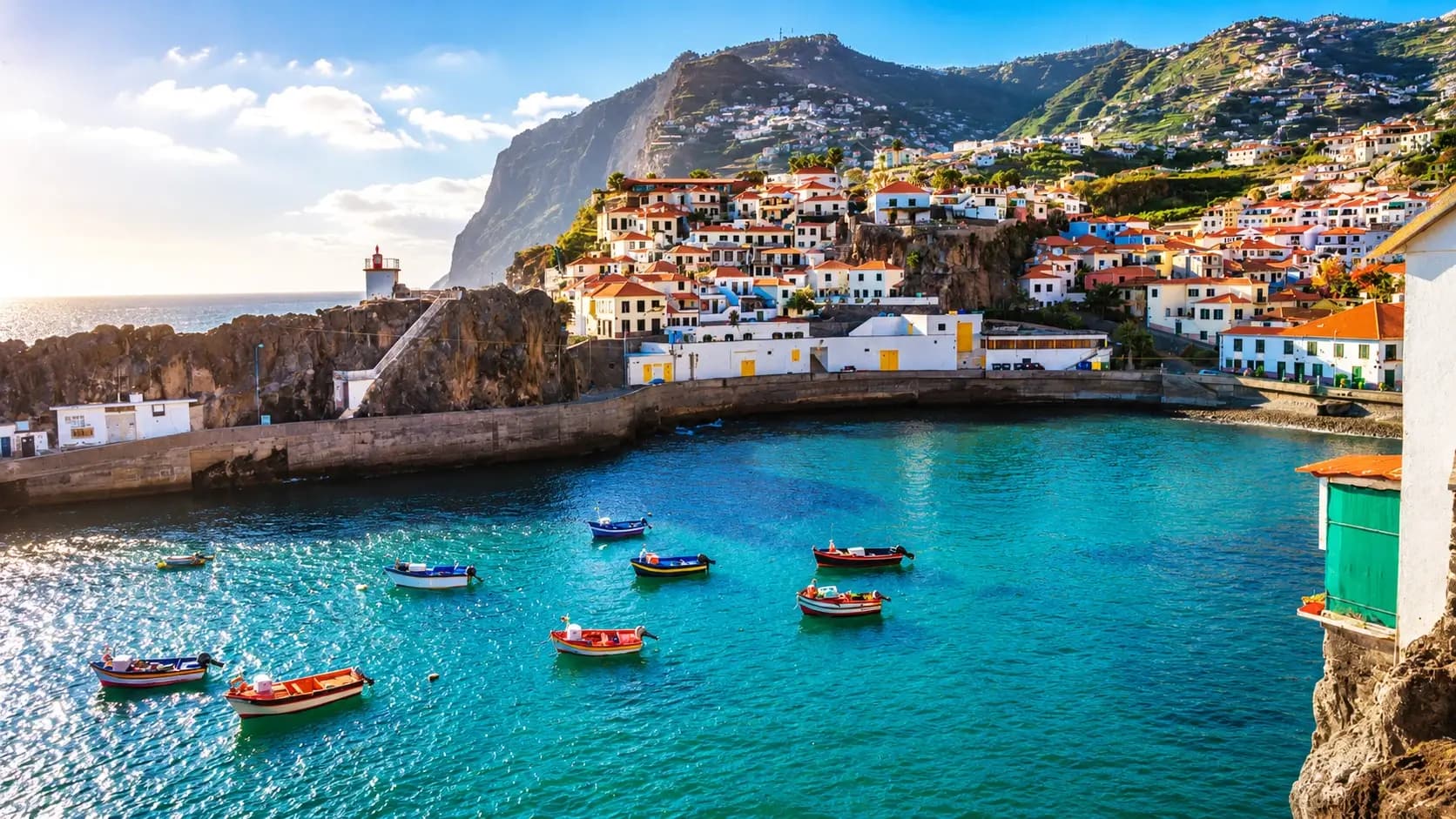 Madeira Portugal travel guide 2026: panoramic view of Funchal bay with dramatic volcanic coastline, terraced hillsides, traditional houses, and Atlantic Ocean - best hotels from €37/night in this Island of Eternal Spring destination