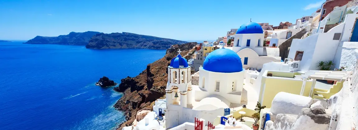 Oia Santorini 2026 - iconic white-washed buildings with famous blue domed churches overlooking the volcanic caldera at sunset, luxury cave hotels with private infinity pools, narrow cobblestone streets, and the most photographed sunset view in Greece