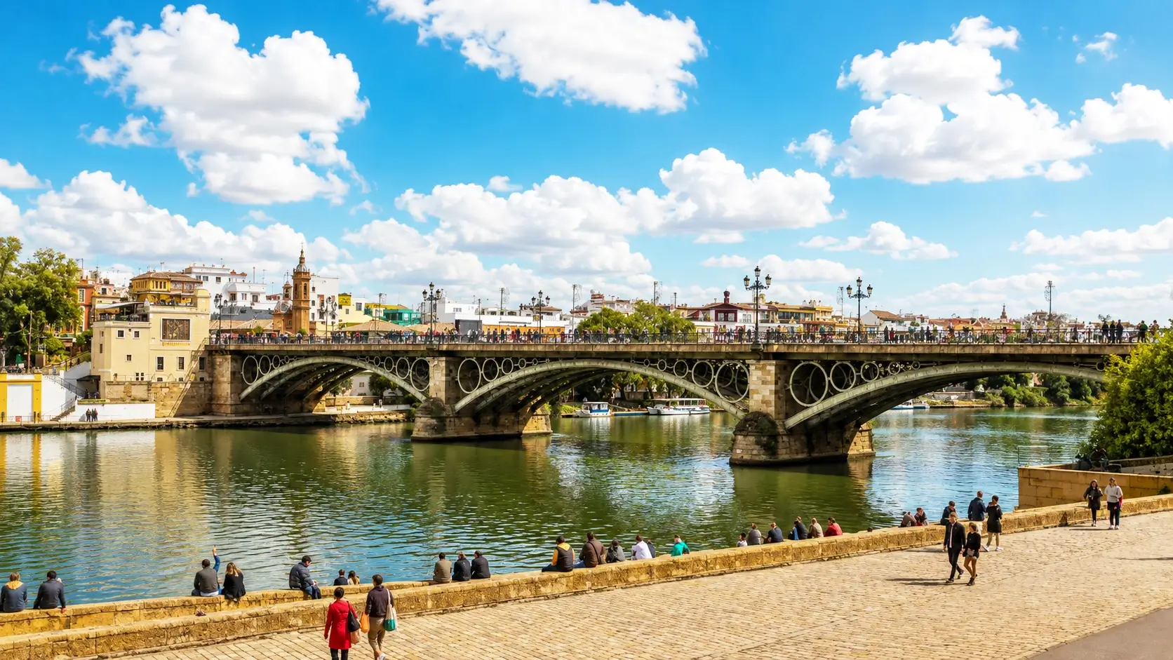 Triana Seville neighborhood 2026: authentic flamenco bars on Calle Betis, colorful ceramic-tiled Triana Bridge over Guadalquivir River, traditional ceramics workshops, Mercado de Triana food market, and budget hotels from €50/night - where locals experience real Seville