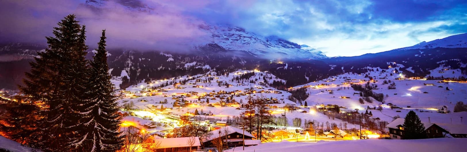 Grindelwald Wengen family ski resort Switzerland Jungfrau region - dramatic Eiger North Face mountain backdrop, car-free Wengen alpine village, historic cogwheel railway, Mannlichen peak at 2343m, gentle intermediate slopes with 103-110km terrain, traditional Swiss chalets for families winter 2026