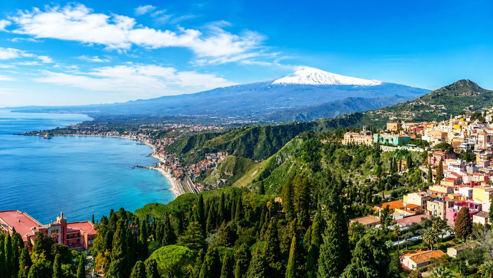 Taormina Sicily travel guide 2026 hero image - Ancient Greek Theatre ruins perched 200m above the Ionian Sea with snow-capped Mount Etna volcano backdrop, golden hour light over terracotta rooftops, where to stay in Taormina from €64 per night in 4 neighborhoods including White Lotus filming location San Domenico Palace